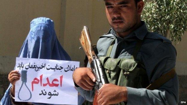 An Afghan woman holds a placard reading in Darri "Be executed" during a protest against a high-profile gang rape case that shocked the capital Kabul, in Herat, Afghanistan, 08 September 2014