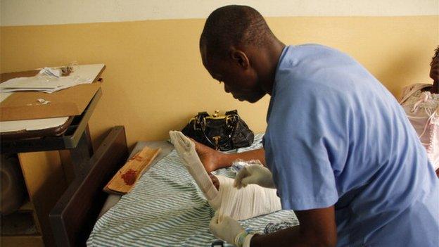 A nurse bandages Gerturde Sumbamala's left leg in a hospital in Accra, after it was broken in a crush in an evangelist church of Accra, on 19 May 2013