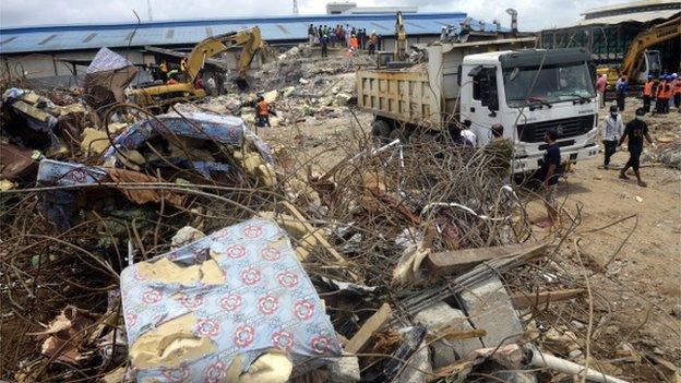 Rescue workers stand behind mattresses used by occupants of the collapsed guesthouse of the Synagogue Church of All Nations (SCOAN) at Ikotun in Lagos on 17 September 2014