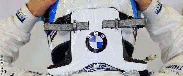 Nick Heidfeld is seen putting on his helmet with HANS safety device attached