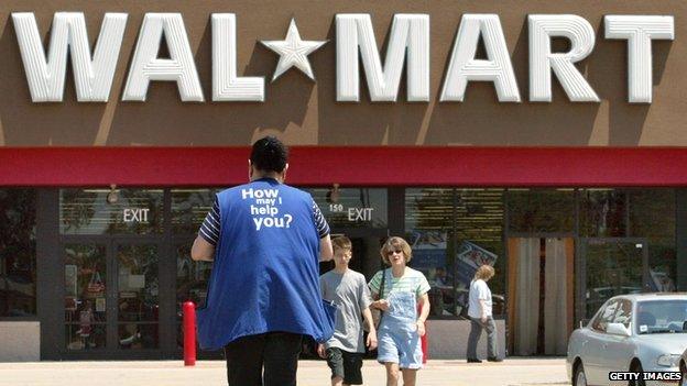 An employee stands outside of Walmart store.