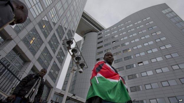 A supporter of Kenya's president Uhuru Kenyatta waits outside the International Criminal Court in The Netherlands on 8 October 2014