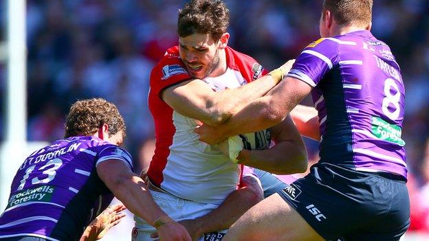 Alex Walmsley for Saints tackled by Wigan's Sean O'Loughlin and Scott Taylor