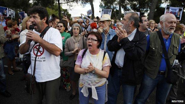 Protesters take part in a demonstration against government spending cuts in the health care sector, outside the Carlos III hospital in Madrid, where a nurse who contracted Ebola is being treated, October 8, 2014