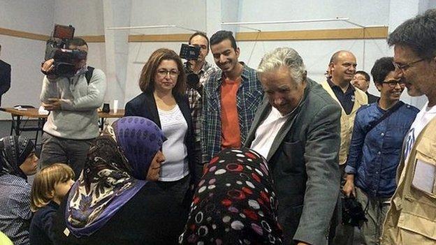 President Jose Mujica greets refugees at the airport near Montevideo 9 Oct 2014