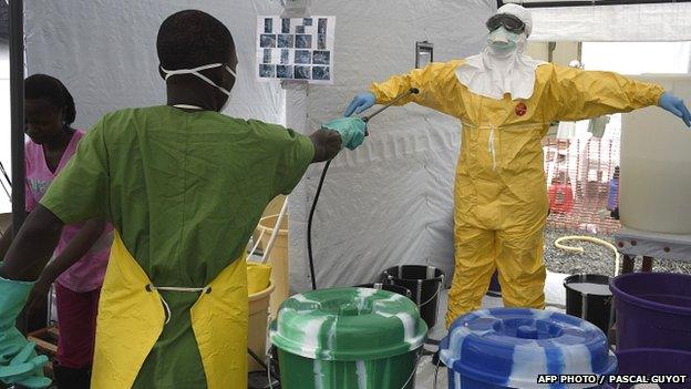 A health worker is decontaminated at a treatment centre