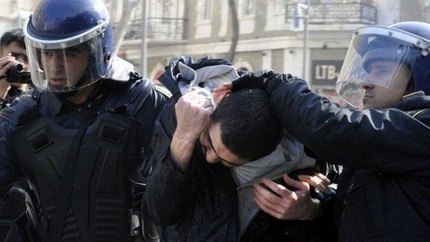 Two policemen lead away a protester in Baku, Azerbaijan on 10 March 2013