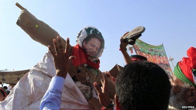 Anti-government supporters beat an effigy of Pakistan"s Prime Minister Nawaz Sharif after attending Eid al-Adha prayers outside the parliament house in the Red Zone during anti-government protest in Islamabad October 6, 2014.
