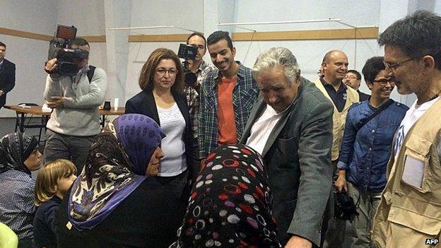 President Jose Mujica greets refugees at the airport near Montevideo 9 Oct 2014