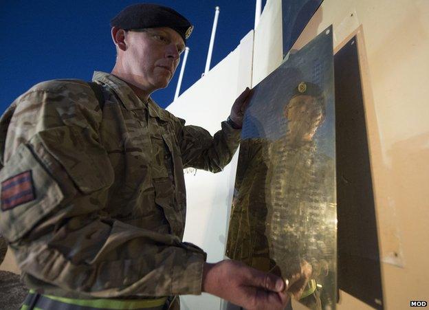 Name plaque being removed from memorial wall