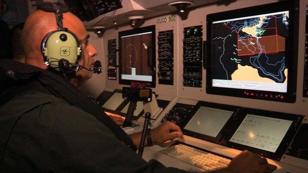 A technician monitors the map for signs of refugee boats