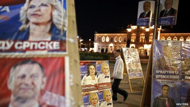 Man walks past election posters