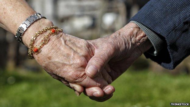 Close up old people hold hands