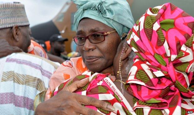 Akaoua Babiana, the wife of Cameroon's deputy prime minister, hugs a relative upon her arrival in Yaounde on 11 October 2014