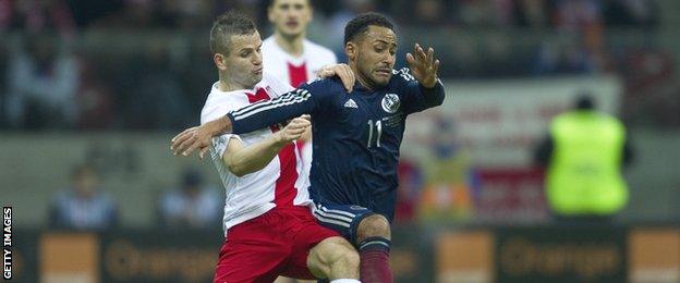 Ikechi Anya tussles for possession with Poland's Tomasz Brzyski in the friendly match in Warsaw in March