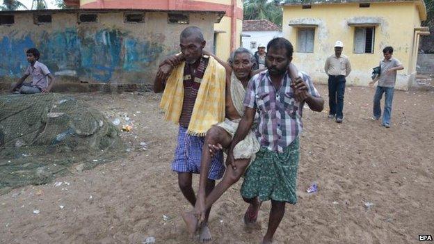 An elderly woman is carried to a relief camp in Kakinada, Andhra Pradesh