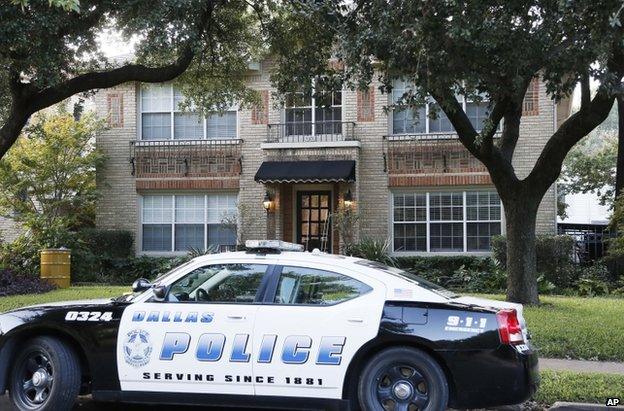 A police car stands outside the apartment complex of the infected health worker in Dallas, 12 October