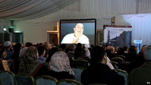 The face of Alan Henning shown on a big screen at the British Muslim Heritage Centre in Manchester