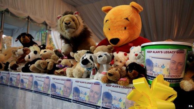 Soft toys and collection buckets at the memorial service for Alan Hemming