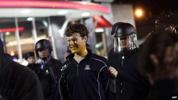 A demonstrator protesting the shooting death of Michael Brown and 18-year-old Vonderrit Myers Jr. reacts to a self defence spray used by police in riot gear in St. Louis, Missouri, 12 October 2014