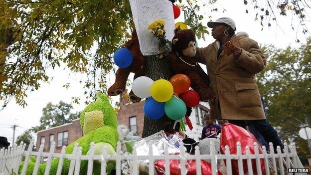 A woman writes a message on a memorial for Vonderrit Myers Jr. in St. Louis, Missouri , 12 October 2014