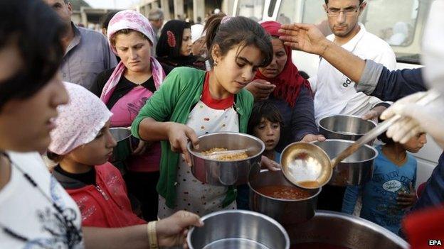 Syrian refugees who fled from Syrian Kobane, try to get food at a refugee camp at Suruc district, Sanliurfa, Turkey, 12 October 2014
