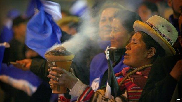 An Aymara indigenous woman burns incense in celebration as supporters wait for President Evo Morales outside the presidential palace in La Paz on 12 October, 2014.