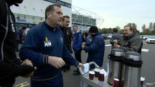 Shrewsbury Town manager Micky Mellon serves up cups of tea to queuing fans at the Meadow