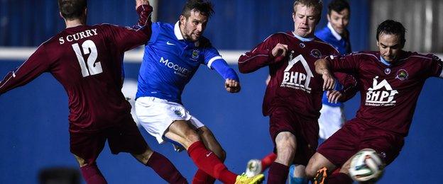 Linfield striker Andy Waterworth gets his shot away despite pressure from three Institute players