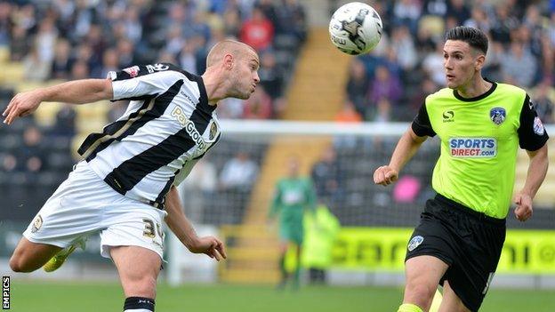 Louis Laing heads the ball clear from Oldham Athletic's Conor Wilkinson