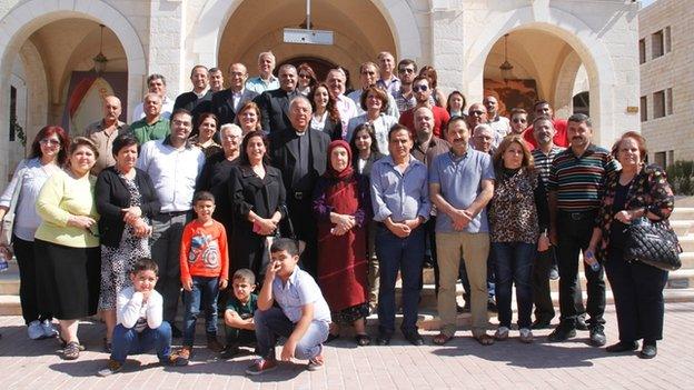 Iraqi Christian refugees pose with speakers from Jordanian Catholic and Muslim institutions coming to their aid in Amman