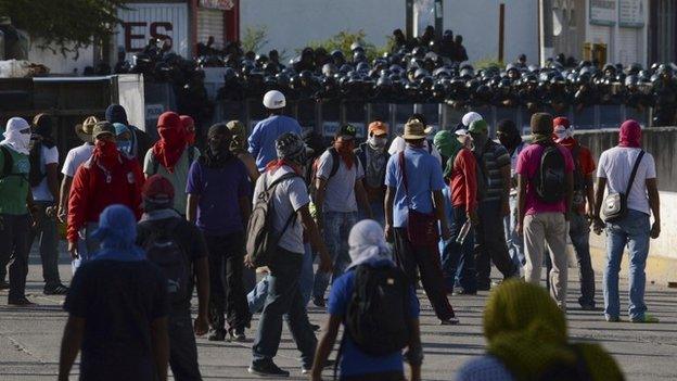 Students stand in front of riot police as they protest outside the City Hall in Chilpancingo, on 13 October, 2014