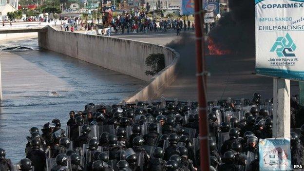 Anti-riot police are on guard as students try to get into the government headquarters in Chilpancingo on 13 October 2014.