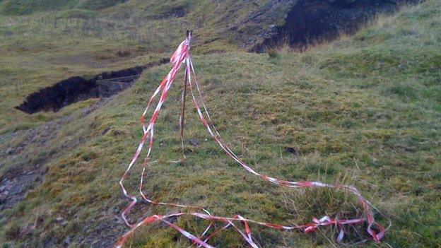 Warning tape surrounding the growing sinkhole