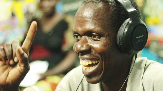 Smiling man with headphones on, in a studio