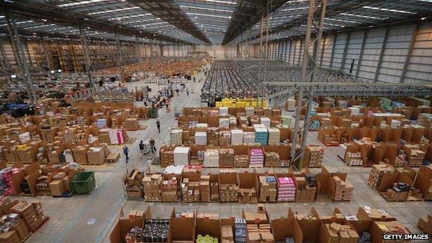 Boxes are piled inside of an Amazon warehouse.