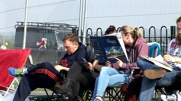 People are sitting in deck chairs queuing to buy houses and apartments in a new development