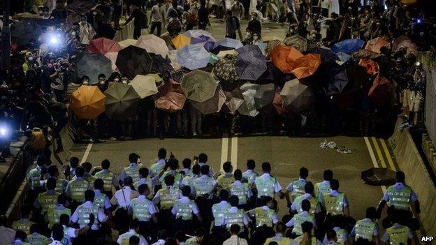 Police forces march toward pro-democracy protesters during a standoff outside the central government offices in Hong Kong - 14 October 2014