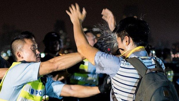 A police officer sprays a pro-democracy protester in the face with pepper spray in Hong Kong on October 15, 2014