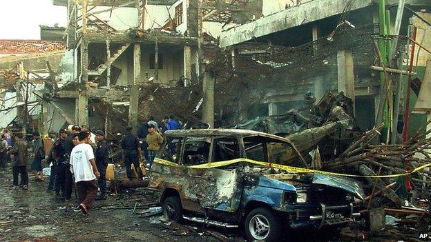 Police officers inspect a bombed nightclub in Denpasar, Bali, Indonesia, on 13 October 2002