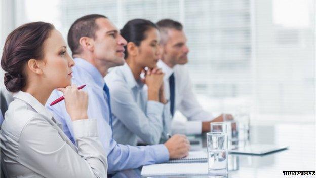 Woman and 3 men in board room