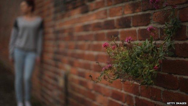 Generic shot of a girl leaning against a wall