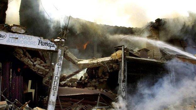 A destroyed two-story Bank of Rajasthan buidling is seen on fire near Jullundur, India, Friday May 3, 2002, after an Indian Air Force MiG-21 jet crashed into the building.