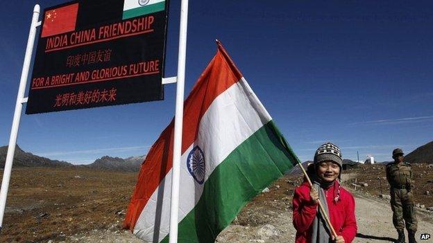 An Indian girl poses for photos with an Indian flag at the Indo China border in Bumla at an altitude of 15,700 feet (4,700 meters) above sea level in Arunachal Pradesh, India.