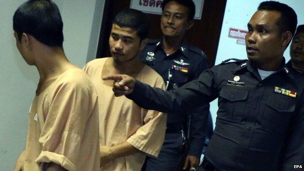 A photo made available on 15 October 2014 shows two Myanmar migrant workers Win (L) and Zaw (L-2), suspects in the killing of two British tourists, are escorted by police officers as they leave Koh Samui Provincial Court in Surat Thani province, southern Thailand