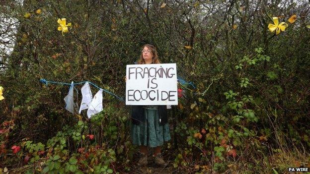 A woman holding an anti-fracking placard