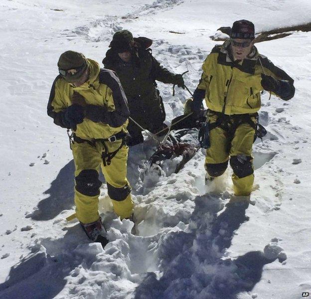 Rescue team members carry a victim of an avalanche from Thorung La pass area in Nepal, 16 October 2014