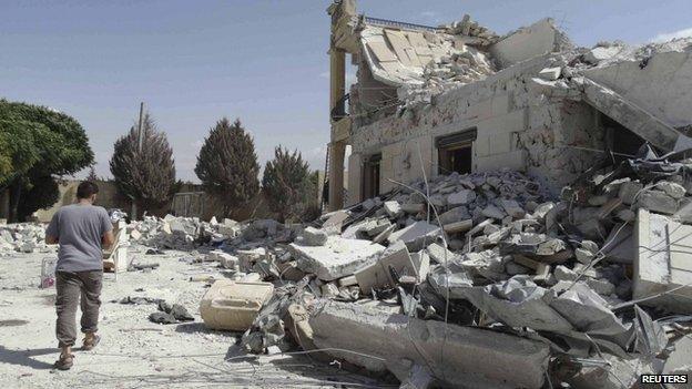 A man walks past a damage building in Aleppo on 27 September 2014