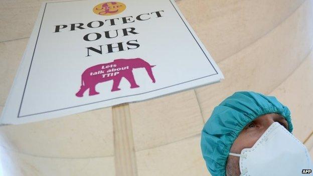 Campaigner with "Protect Our NHS" banner