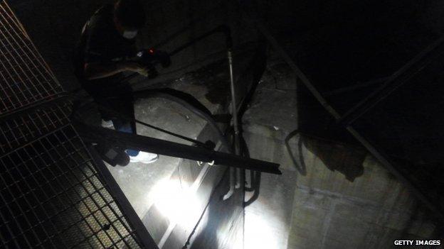 A policeman inspects the collapsed ventilation grill